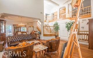 dining space with a high ceiling, hardwood / wood-style floors, and a notable chandelier