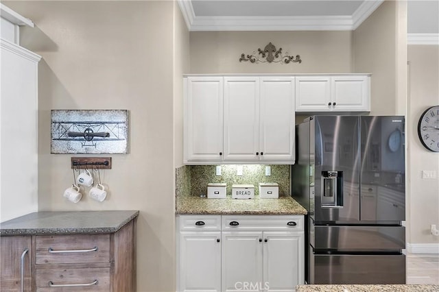 kitchen featuring white cabinetry, stainless steel fridge with ice dispenser, and backsplash