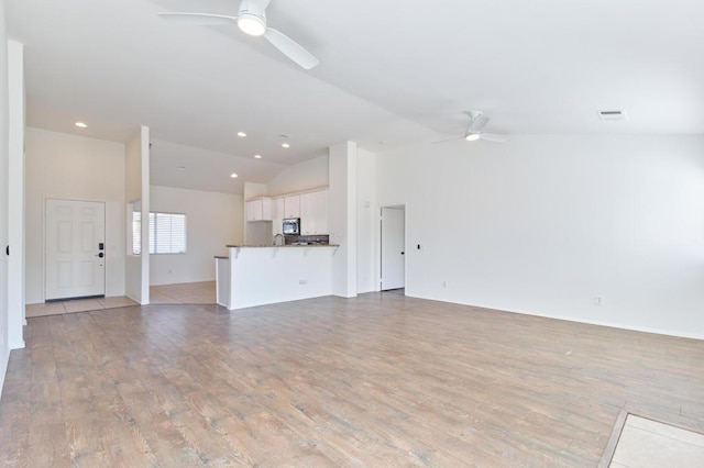 unfurnished living room with lofted ceiling, ceiling fan, and light hardwood / wood-style floors