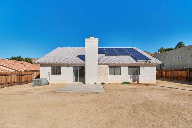 back of house featuring a patio area and solar panels