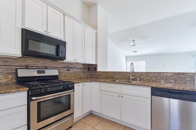 kitchen with stainless steel appliances, sink, dark stone counters, and white cabinets