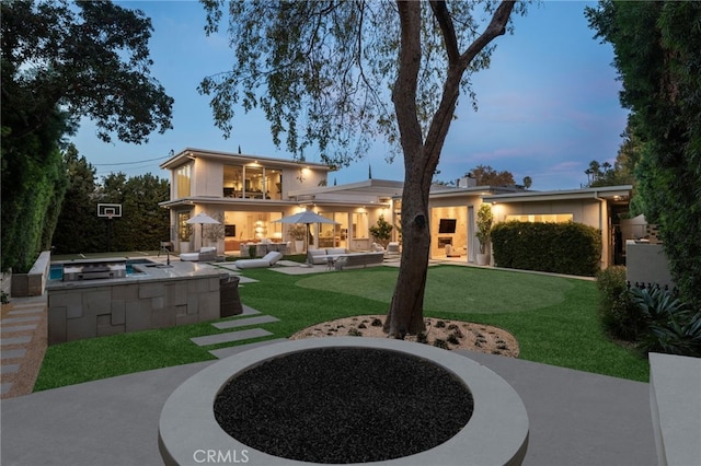 4727 Alonzo Ave, Encino, CA 91316 - back house at dusk with a yard, a patio, and a balcony
