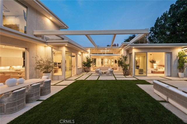 4727 Alonzo Ave, Encino, CA 91316 - back house at dusk featuring an outdoor living space, a lawn, and a patio