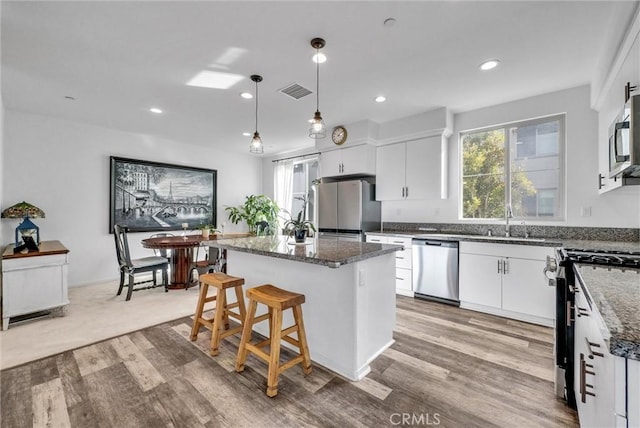 kitchen with a center island, white cabinets, and appliances with stainless steel finishes