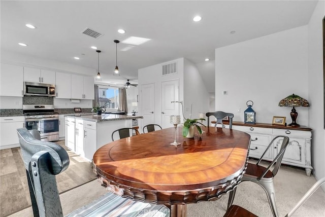 dining room with ceiling fan and light hardwood / wood-style floors