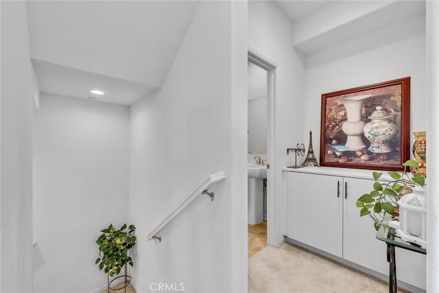 hall with light colored carpet