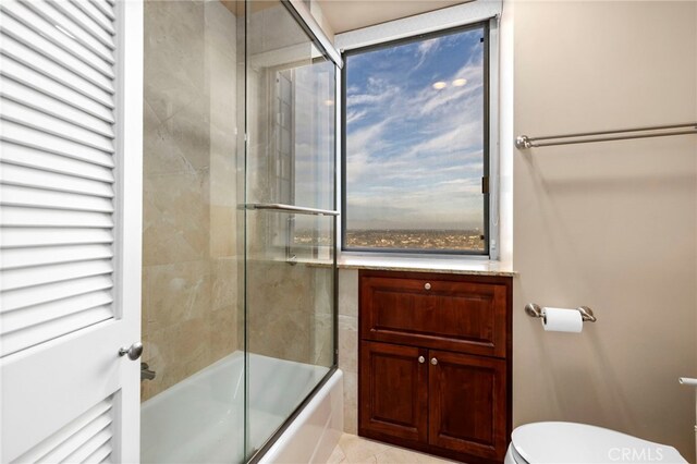 bathroom with toilet and combined bath / shower with glass door