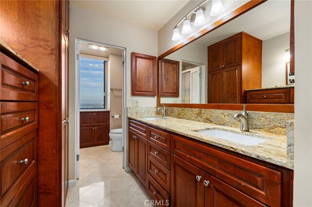 bathroom featuring tile patterned flooring, vanity, and toilet