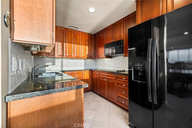 kitchen featuring sink, backsplash, black appliances, and dark stone counters