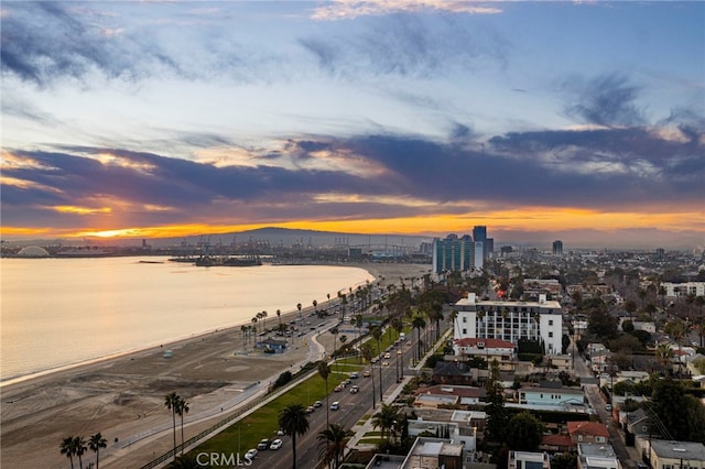 aerial view at dusk featuring a water view