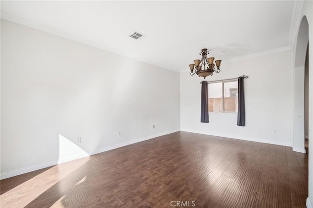 spare room with ornamental molding, dark hardwood / wood-style flooring, and a chandelier