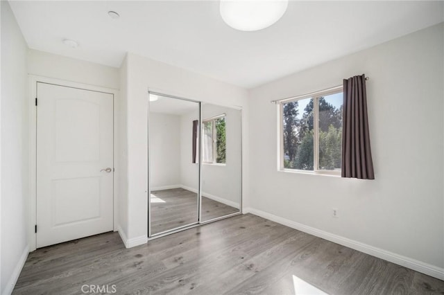 unfurnished bedroom with light hardwood / wood-style floors and a closet