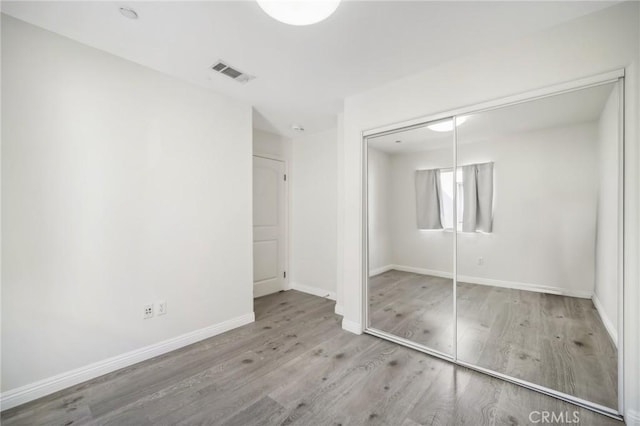 unfurnished bedroom with light hardwood / wood-style floors and a closet