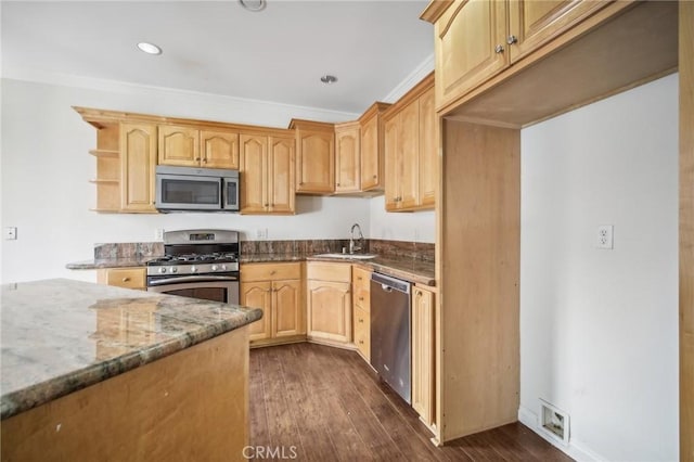 kitchen featuring sink, dark wood-type flooring, stainless steel appliances, ornamental molding, and dark stone counters