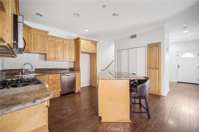 kitchen featuring a kitchen island, stone countertops, dark hardwood / wood-style floors, light brown cabinetry, and stainless steel appliances