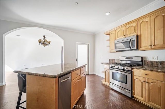 kitchen featuring a kitchen island, ornamental molding, dark hardwood / wood-style floors, and appliances with stainless steel finishes