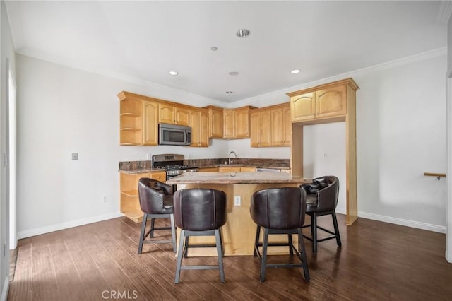 kitchen with a kitchen breakfast bar, dark hardwood / wood-style flooring, ornamental molding, a center island, and stainless steel appliances