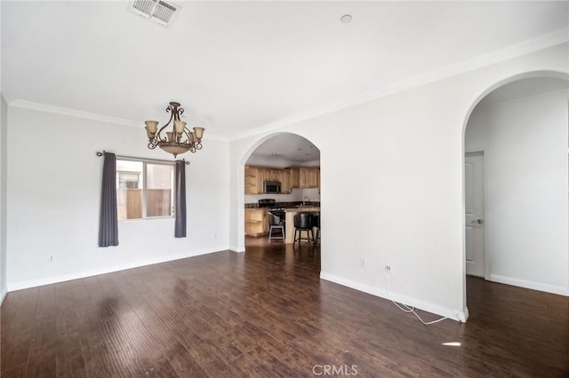 empty room with ornamental molding, dark hardwood / wood-style floors, and a notable chandelier