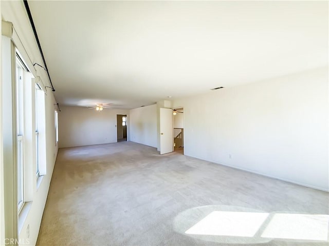 carpeted spare room with ceiling fan