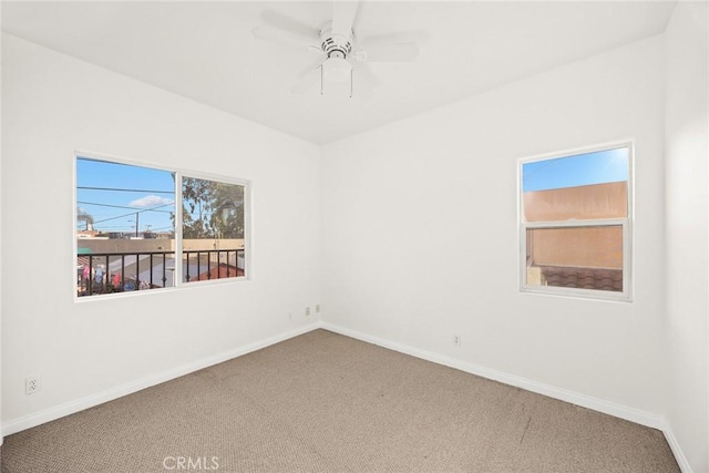 carpeted spare room with ceiling fan