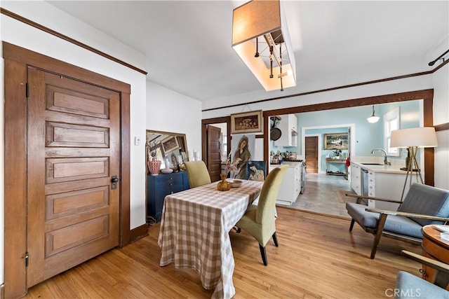 dining area with sink and light wood-type flooring