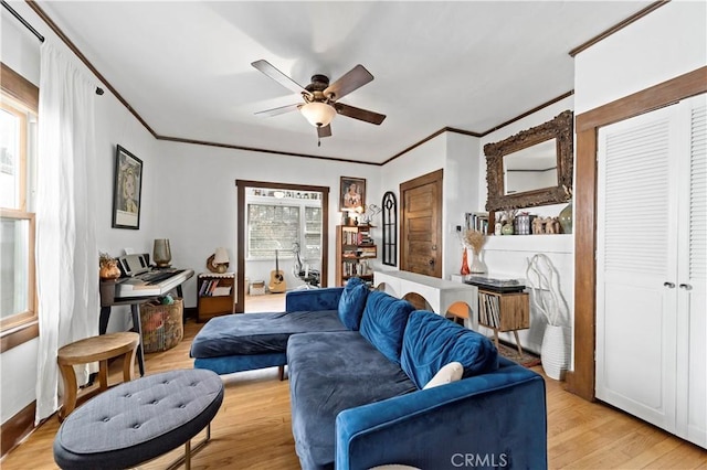 living room featuring crown molding, ceiling fan, and light hardwood / wood-style flooring