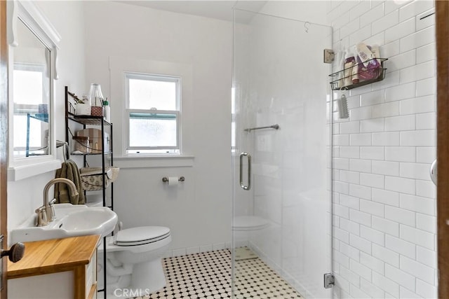 bathroom with vanity, toilet, and a shower with shower door