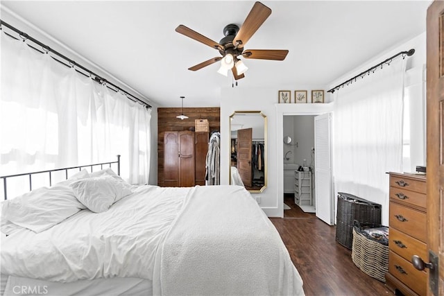 bedroom featuring ceiling fan, wooden walls, and dark hardwood / wood-style flooring