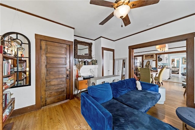 living room featuring crown molding, light hardwood / wood-style flooring, and ceiling fan