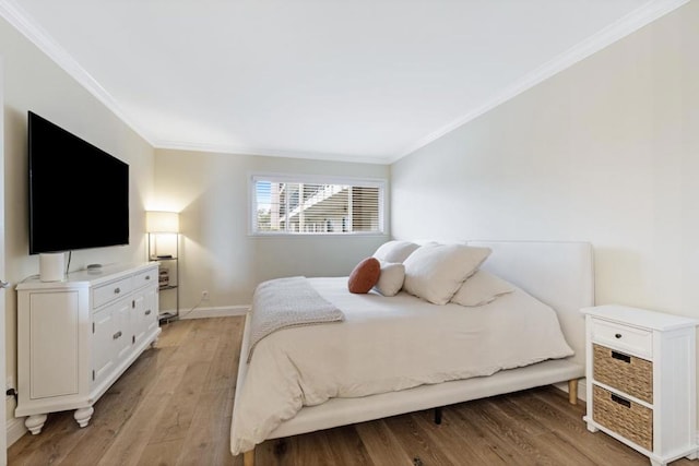 bedroom featuring ornamental molding and light wood-type flooring