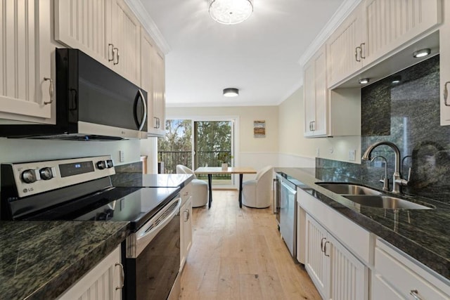 kitchen featuring stainless steel appliances, ornamental molding, sink, and white cabinets