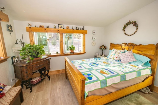 bedroom with vaulted ceiling and light wood-type flooring