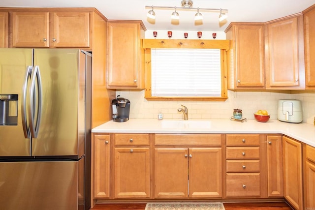 kitchen with sink, decorative backsplash, and stainless steel refrigerator with ice dispenser