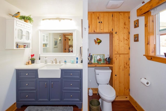 bathroom with hardwood / wood-style flooring, vanity, a healthy amount of sunlight, and toilet