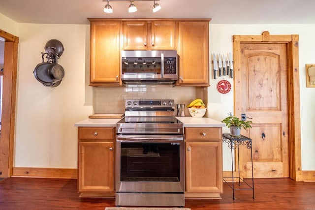 kitchen with appliances with stainless steel finishes, dark hardwood / wood-style floors, and backsplash