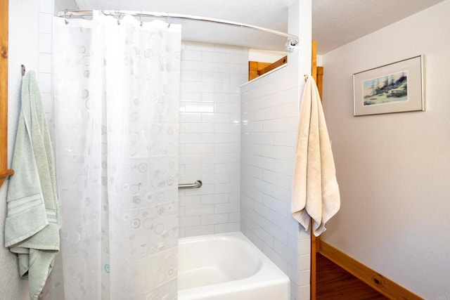 bathroom with hardwood / wood-style flooring and shower / tub combo