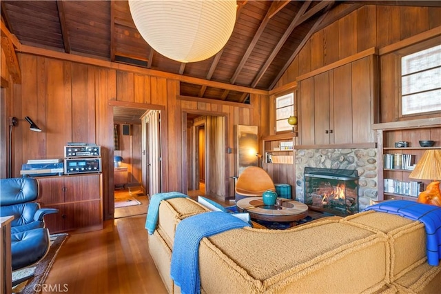 living room featuring wooden walls, a fireplace, vaulted ceiling with beams, dark wood-type flooring, and wooden ceiling