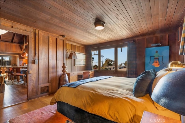 bedroom with wood walls, hardwood / wood-style floors, and wooden ceiling