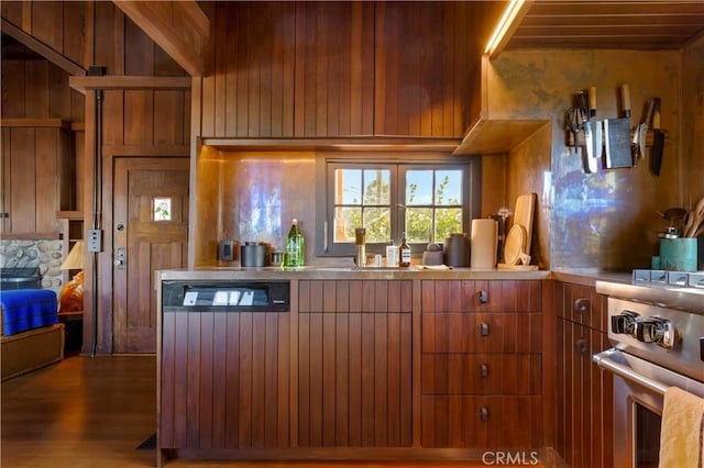 kitchen with hardwood / wood-style floors, stainless steel range, and wooden walls