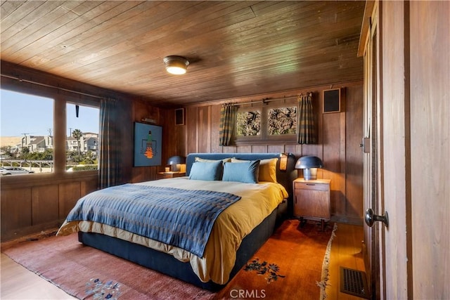 bedroom with hardwood / wood-style flooring, wood walls, and wooden ceiling