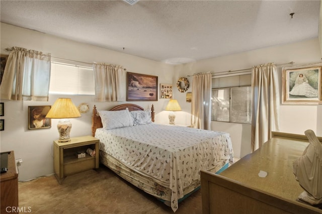 bedroom featuring carpet flooring and a textured ceiling