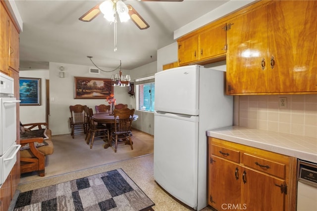 kitchen with ceiling fan, tile counters, backsplash, and white appliances