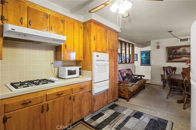 kitchen with ceiling fan, white appliances, and backsplash