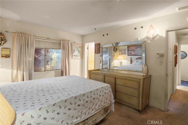 bedroom featuring a textured ceiling and carpet