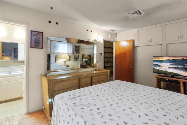 carpeted bedroom with sink and a textured ceiling