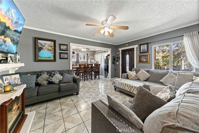 living room featuring crown molding, ceiling fan, a textured ceiling, and light tile patterned floors