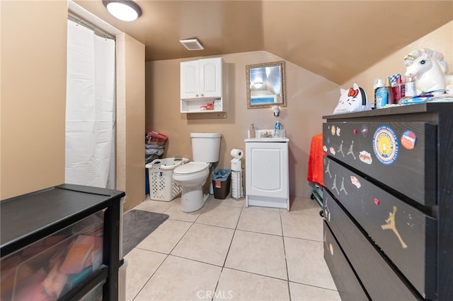 bathroom featuring lofted ceiling, toilet, and tile patterned flooring