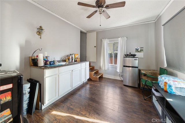 kitchen featuring white cabinetry, ornamental molding, stainless steel fridge, and dark hardwood / wood-style flooring