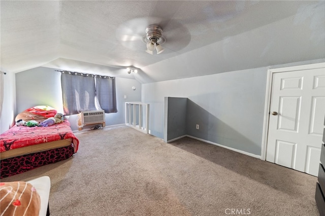 bedroom featuring an AC wall unit, lofted ceiling, carpet flooring, ceiling fan, and a textured ceiling