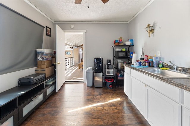 kitchen featuring sink, white cabinets, dark hardwood / wood-style flooring, ceiling fan, and a textured ceiling